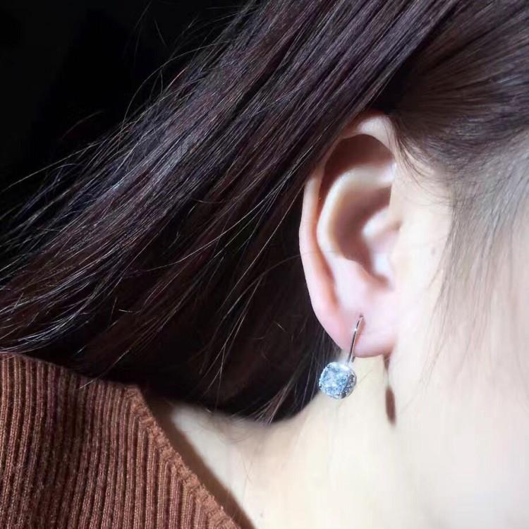 Boucles d’oreilles avec petit diamant carré.