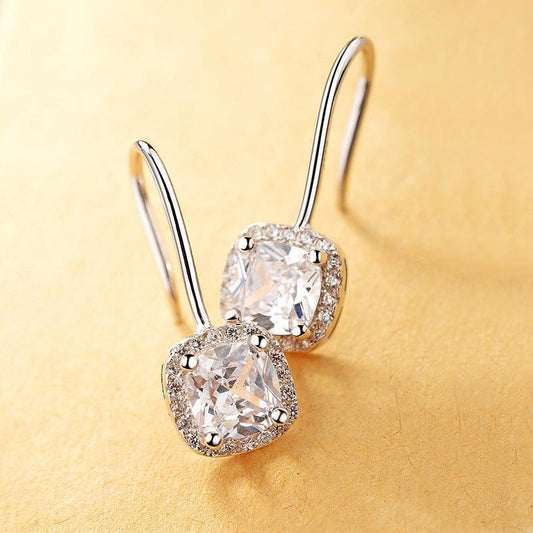 Boucles d’oreilles avec petit diamant carré.