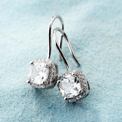 Boucles d’oreilles avec petit diamant carré.